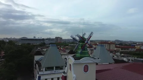 Distinctive rooftop windmill spins above a sprawling urban tapestry, captur.. Stock Footage 325309224