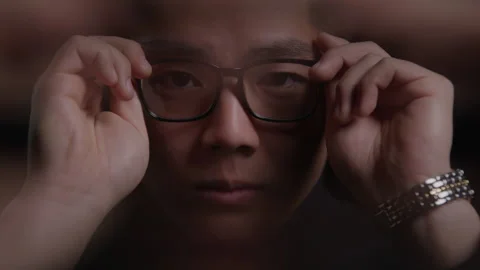 Distorted Close-up Portrait of Male Model Putting on Glasses Under Studio Light Vídeo Stock 270301940