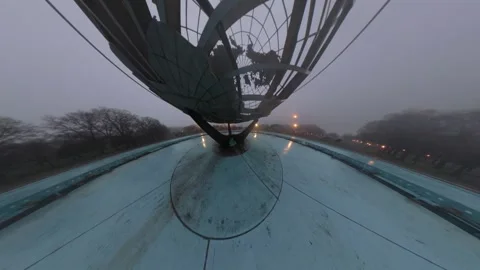 A distorted drone view of the Unisphere in Flushing Meadows Corona Park on a Stock Footage 333337048