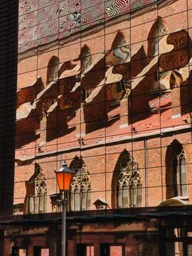 Distorted reflection of old red brick church with arched windows and tiled roof Stock Photos