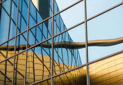 Distorted reflection of a yellow building in the mirrored windows of an offic Foto stock