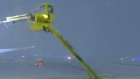 Distorted view of de-icing process on airplane wing viewed from passenger seat Stock Footage 103460336
