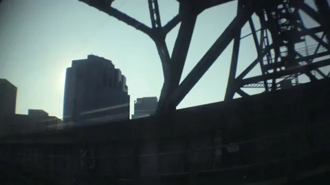 Distorted view moving under a silhouetted train bridge Stock Footage 159006899