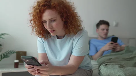 Distracted couple using smart phones in bed ignoring each other Stock Footage 333261001