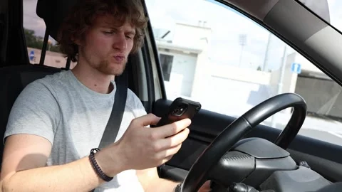 Distracted driver checks smartphone while driving and ignores the road Video stock 343719892