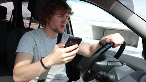 Distracted driver looks at smartphone then suddenly brakes to avoid danger Stock Footage 343719844