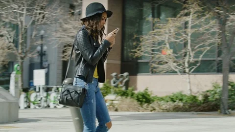 Distracted woman texting on cell phone walking into post on sidewalk / Salt Lake Stock Footage