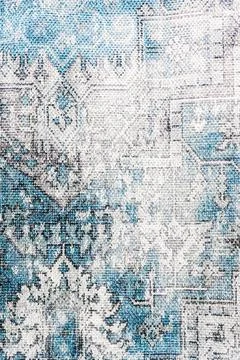 Distressed carpet texture with an oriental pattern in blue, white, and gray.. Stock Photos