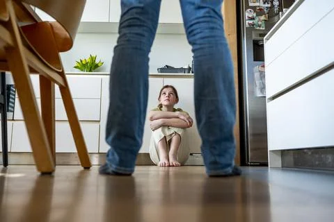 Distressed child facing aggressive parenting and emotional fear at home. Stock Photos