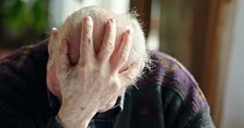 Distressed elderly man holding his fist to his forehead and shaking his head Stockbeeldmateriaal 88633662