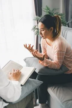 Distressed female client covers face while therapist writes notes during pr.. Stock Photos