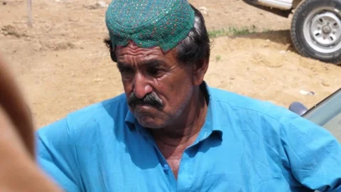 A distressed looking man wearing blue attire waiting in que to receive aid Stock Footage 210110876