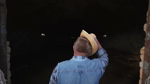 A distressed man near an empty cattle hangar. Farmer near an empty barn. Stock-Footage 135870991
