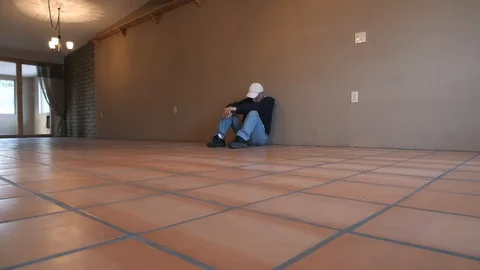 A distressed man sitting in an empty house Stock Footage 122923732