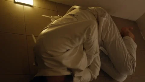 Distressed Man in Straitjacket Expressing Madness in Confined Cell Stock Footage 325022450
