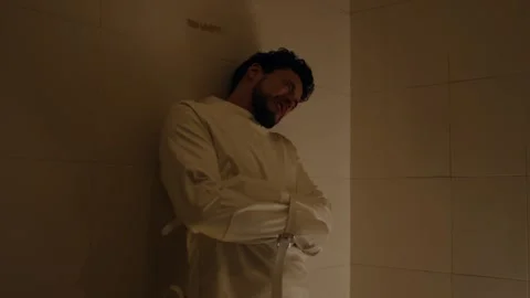 Distressed Man in Straitjacket Isolated in a Cell Interior Stock Footage 324959645