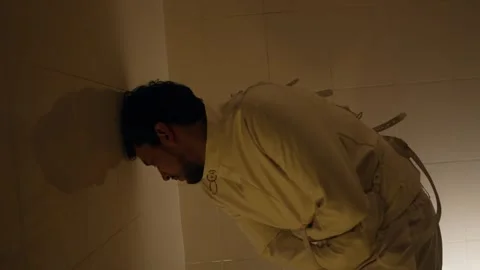 Distressed Man in Straitjacket Shows Intense Mental Struggle in Cell Stock Footage 325022396