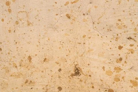 Distressed splatter plaster wall with dense brown marks, patchy erosion, sand Stock Photos