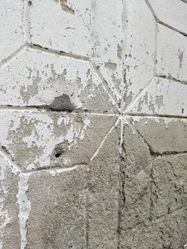 Distressed white wall texture with geometric pattern and peeling paint. Stock Photos
