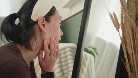 Distressed Woman Checking Her Acne in the Mirror with Visible Concern Indoors Stock Footage 310356288