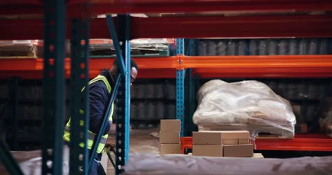 Distribution, dancing and black man in warehouse, trolley and parcel with Stock Footage 321124009