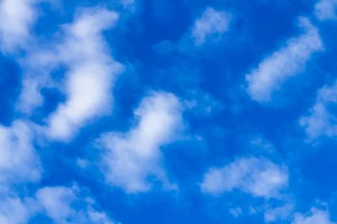 Distribution of white clouds on the clear blue sky for background texture Stock Photos