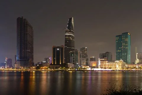 District 1 of Ho Chi Minh City at night seen from across the Saigon River w.. Stock Photos