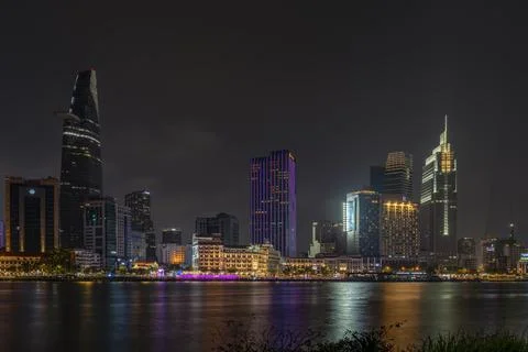 District 1 of Ho Chi Minh City at night seen from across the Saigon River w.. Stock Photos
