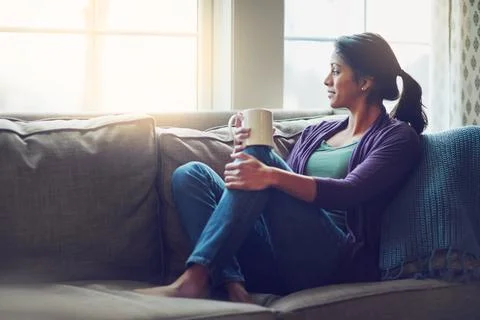 Ditch the to do list and just relax. a young woman relaxing on the sofa with a Stock Photos
