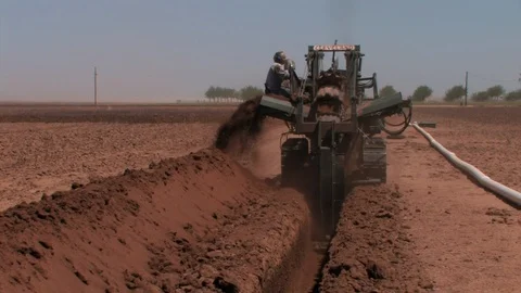 Ditch Witch operating in cotton field, zoom in to excavating buckets. Stock Footage 88681306