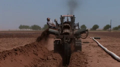 Ditchwitch operator extracting dirt for water line in cotton field. Stock Footage 88681563