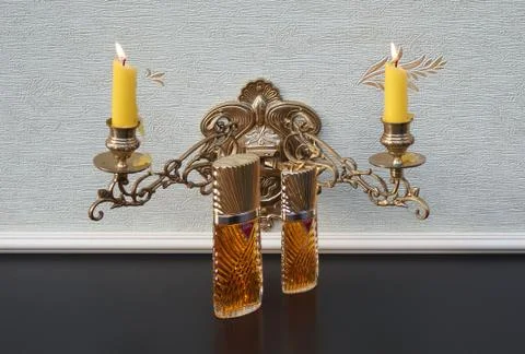 Diva big perfume bottle in front of a candelabra with shining candles Foto stock