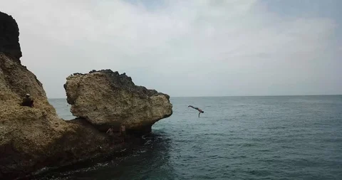 Dive Off Rock into the Ocean Bali Drone Shot Stock Footage 106787282