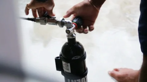 Dive shop worker adjusts small dive tank valve Stock Footage 87374453