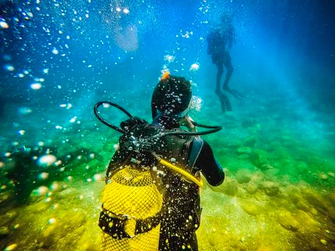 Diver back to camera, looking to another diver in the sea. Foto stock