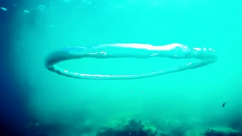 Diver Blow Bubble Rings while freediving in Spain Stock Footage 130912026