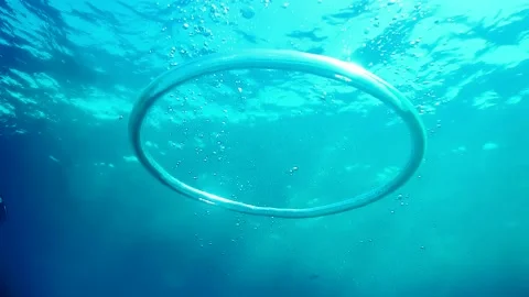 Diver Blow Bubble Rings while freediving in Spain Stock Footage 130912038