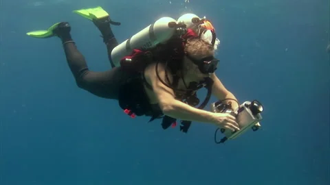 Diver with camera in his hands takes pictures of underwater video. Stock Footage 232977661