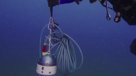 Diver carrying an underwater seismometer Stock Footage 263115182