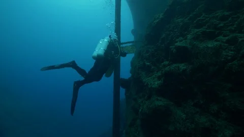 Diver cleans plate at the bottom of the lake, San Domenico Lake Stock Footage 104594020