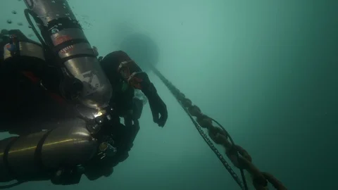 Diver climbs up surface following chain of the buoy, Albano lake, Italy Stock Footage 107600811