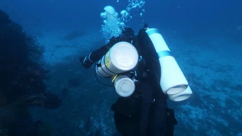 Diver with DPV runs alongside rocks on the seabed, Ustica, Mediterranean sea Stock Footage 127052346