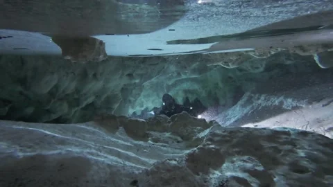 A diver emerges from an underwater cave Stock Footage 277230231