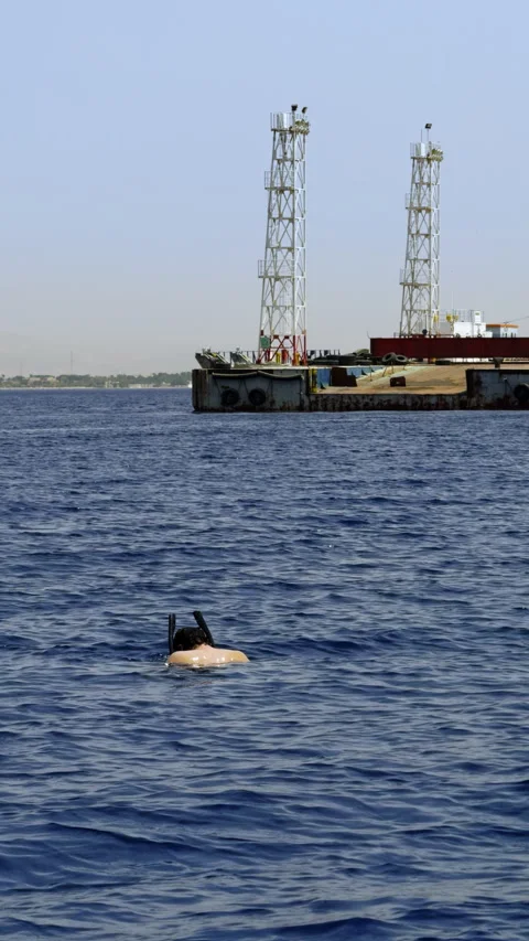 A diver explores the expansive and deep blue sea, swimming near offshore Stock Footage 285307599