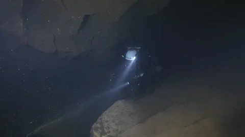Diver explores the rocks in the cave and follows guideline, Amaseno,Italy Stock Footage 224662242