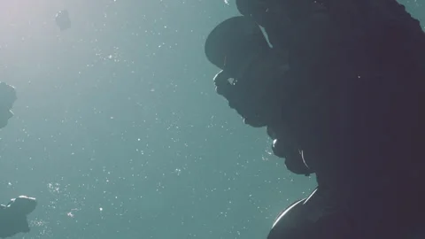 Diver explores underwater scene with air bubbles and rocky formations Stock Footage 345043073