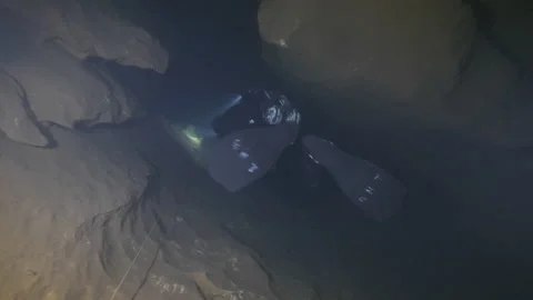 Diver with flashlight explore the rocks of the cave. Risorgneza Amaseno, Italy Stock Footage 224512758