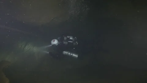 Diver with flashlight explore the rocks of the cave. Risorgneza Amaseno, Italy Stock Footage 224519003