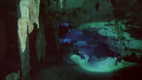 Diver framed by stalactite formations in cave Video stock 331790804