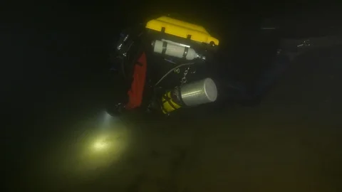 Diver illuminates the bottom of the lake to find a guide line, Albano lake,Italy Stock Footage 107601308